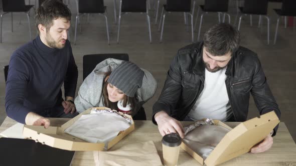 A Group of Young Designers Led By the Head are Working on the Project of Design Office and Eating