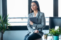 Beauty business woman using her digital tablet while sitting on a desk in a modern startup office. - PhotoDune Item for Sale