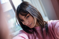Pretty young woman taking a selfie near to the window in the living room at home. - PhotoDune Item for Sale