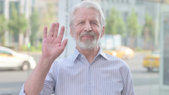 Welcoming Old Man Waving Hand for Hello Outdoor