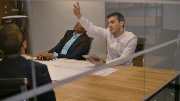 Young Colleagues Team Sitting at a Table, Man with Virtual Reality Goggles, Testing Virtual Reality