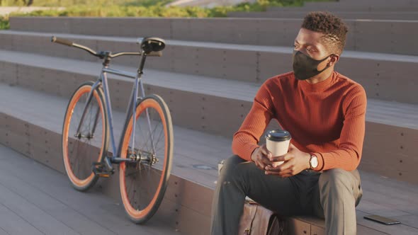 African American Businessman in Face Mask Resting in Park