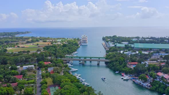 Yacht cruising out of Dulce river from La Romana marina, cruise liner anchored, Caribbean