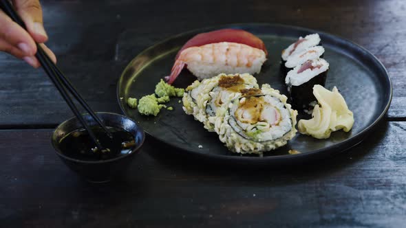 Hands of woman with chopsticks and sushi