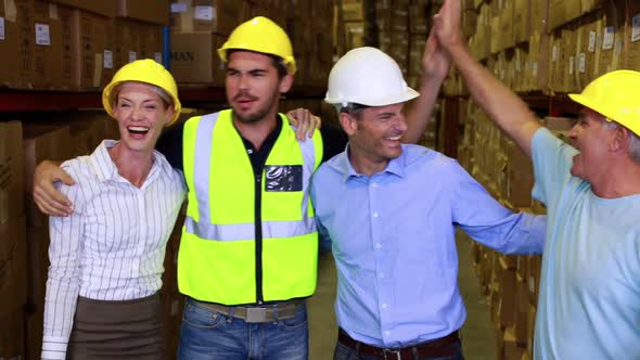 Warehouse Team Smiling and High Fiving Each Other