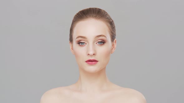 Studio portrait of young, beautiful and natural woman over grey background.