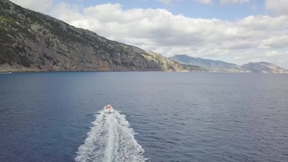 Aerial view of a motorboat at the coast of Cala Gonone, Sardinia, Italy.