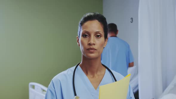 Front view of African american female doctor looking at camera in the ward at hospital