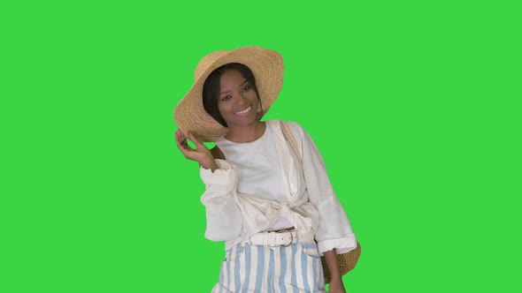 Smiling Young African American Woman in a Straw Hat Posing on a Green Screen, Chroma Key.