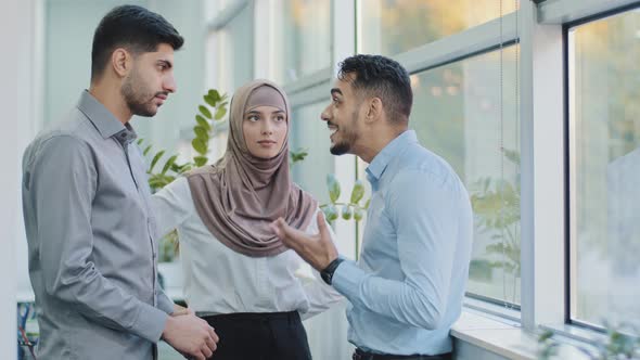 Diverse Friends Multiethnic Colleagues Arab Muslim Woman in Hijab and Two Indian Men Chatting