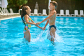 Children sideways to camera holding hands in pool - PhotoDune Item for Sale