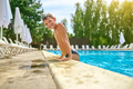 Boy smiling at camera touching pool edge - PhotoDune Item for Sale