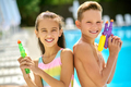 Girl and boy with water guns looking at camera - PhotoDune Item for Sale