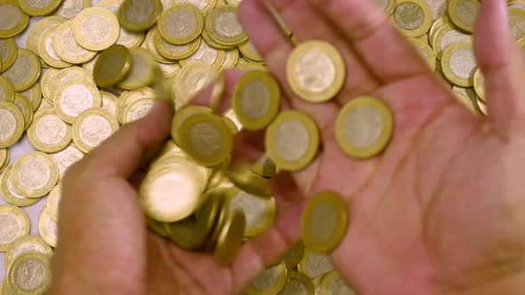 Hands Taking A Fountain Of Mexican Coins