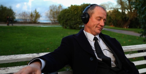 Senior Businessman Enjoying Music Outdoors 