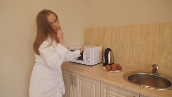 Woman in Bathrobe Hurrying at Home.