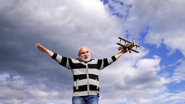 Happy Greybeard Man Imagine Flying on Toy Plane in Sky Imagination Flight