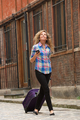 Full length woman walking with mobile phone and suitcase on street - PhotoDune Item for Sale