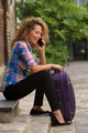 happy travel woman talking with mobile phone sitting on street with suitcase - PhotoDune Item for Sale