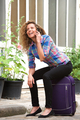 smiling travel woman sitting on suitcase talking with cellphone on street - PhotoDune Item for Sale
