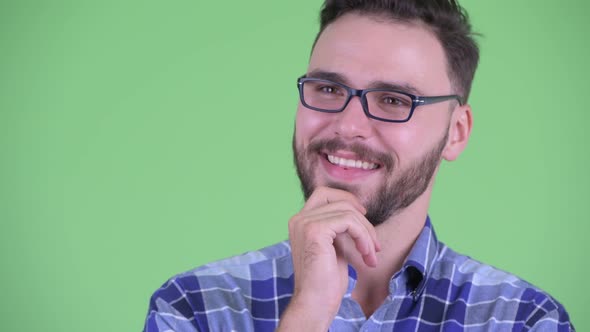 Face of Happy Young Bearded Hipster Man Thinking and Looking Up