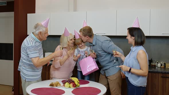 Mother, Father and Grandparents Giving Gift Bag for Child Girl. Celebrating Birthday Anniversary