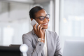 Successful african business woman talking on phone in office - PhotoDune Item for Sale