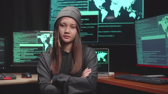 Young Asian Woman Hacker Looking, Pose To Camera, Code On Multiple Computer Screens