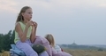 girls eating sunflower seeds on mown rye in field - PhotoDune Item for Sale