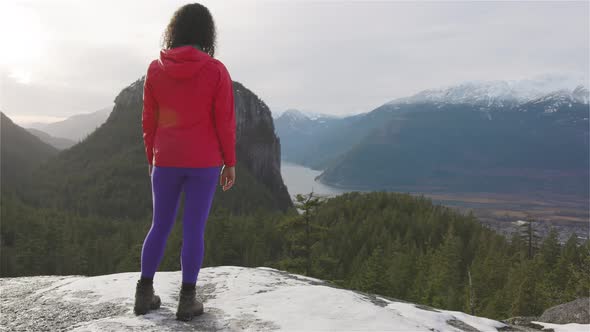 Adventurous Girl Hiking in the Mountains During a Sunny Winter Sunset