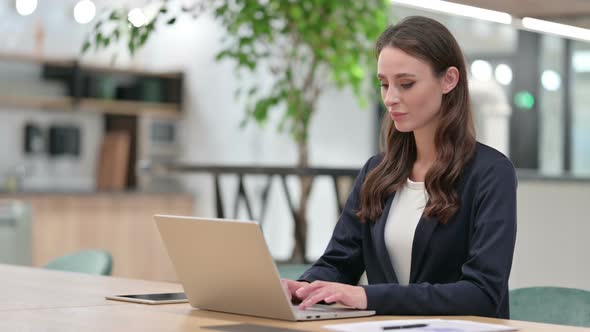 Businesswoman with Laptop Smiling at the Camera 