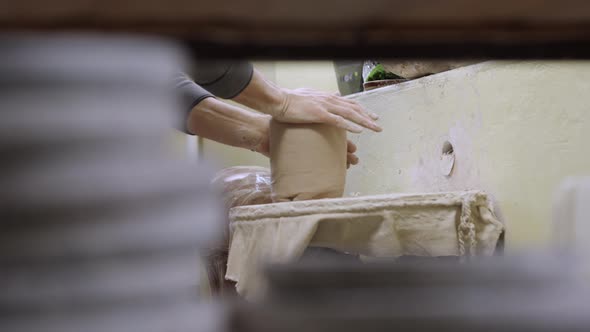 The Potter's Male Hands Knead and Form Soft Wet Piece of White Clay