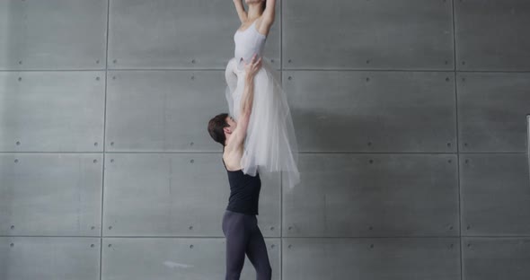 Elegant Couple of Classical Ballet Dancers Rehearsing a Dance on a Gray Background a Young Couple
