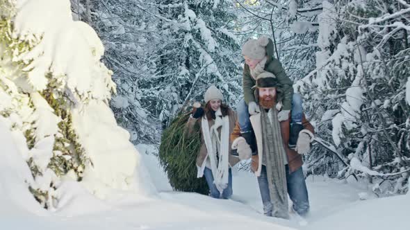 Family Walking through Deep Snow in Forest