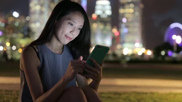 Woman looking at cellphone at night 