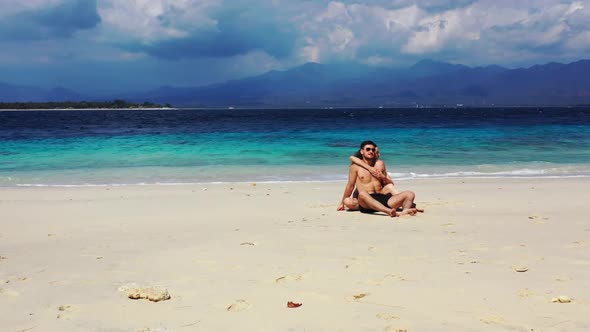 Man and lady in love on tropical tourist beach time by blue water with white sand background of Indo