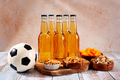 Beer and snack on wooden table with football ball, football game night food - PhotoDune Item for Sale