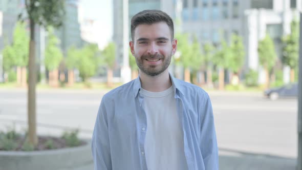 Outdoor Portrait of Young Man Smiling at Camera