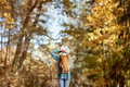 A girl in a beige hat looks at the autumn forest - PhotoDune Item for Sale