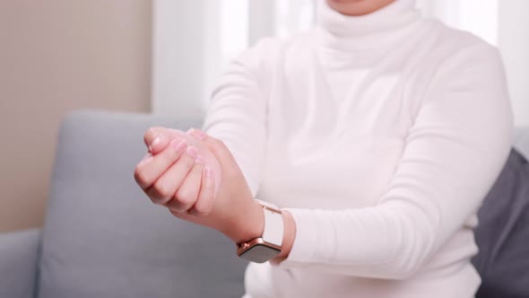 Woman performing self-massage on her right arm wrist. Technology abuse concept.