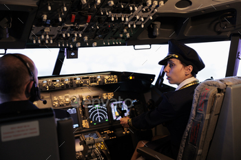 Woman copilot in uniform flying airplane with cockpit command