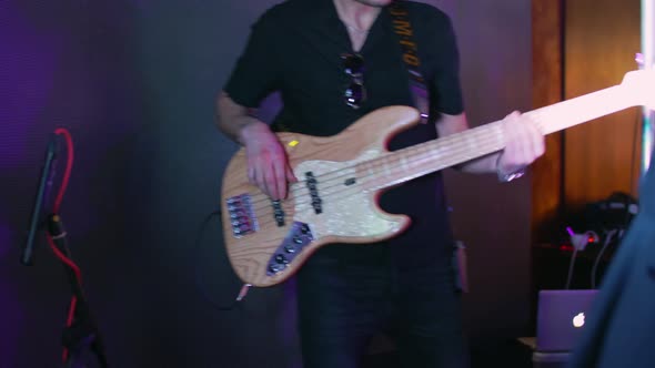 A Caucasian Man Plays Electric Bass Guitar at a Concert Party Music Party Neon Colors Bass Guitar