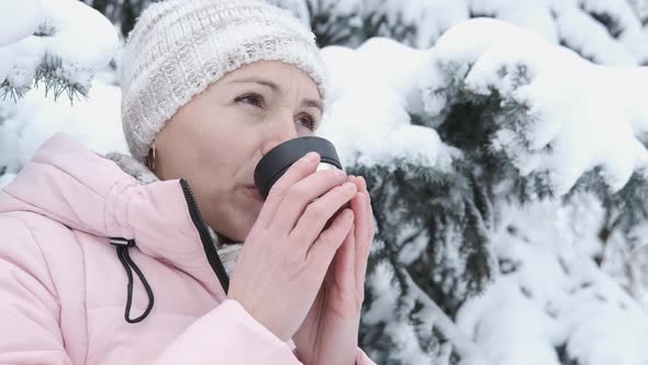 Woman drinking tea in nature. 