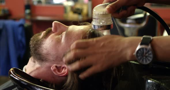 Barber washing mans hair 