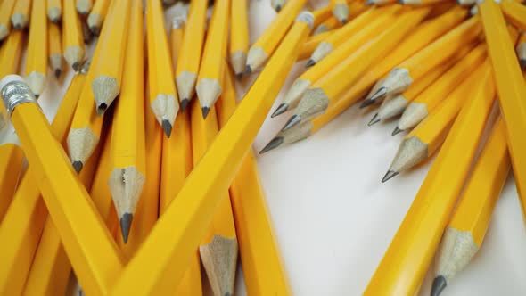 Yellow Pencils Randomly Lie on a White Background