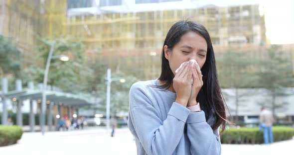 Woman sneeze at outdoor city