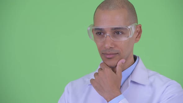 Face of Happy Bald Multi Ethnic Man Doctor with Protective Eyeglasses Thinking and Looking Up