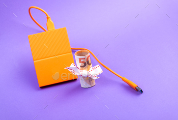ift ribbon and external portable hard disk drives  on purple background