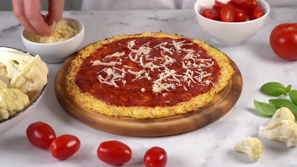 Close Up of Woman's Hands Preparing Healthy Cauliflower Pizza