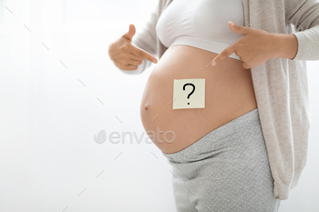 nant woman pointing at question mark on paper sticker on her big tummy, white background, panorama with empty space